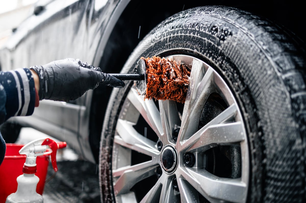 Cura e finitura del cerchio dell'auto con spazzola e sapone