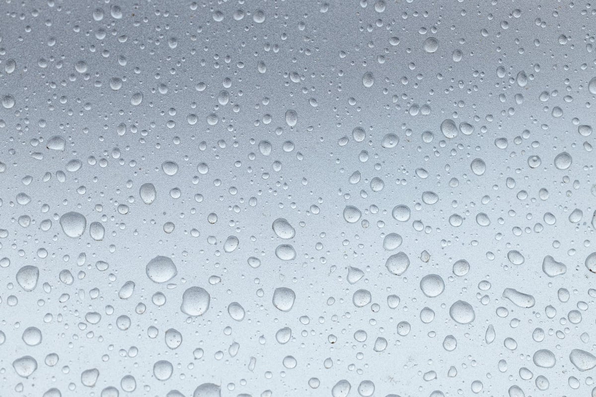 Gocce d'acqua sulla superficie in metallo argentato dopo il lavaggio