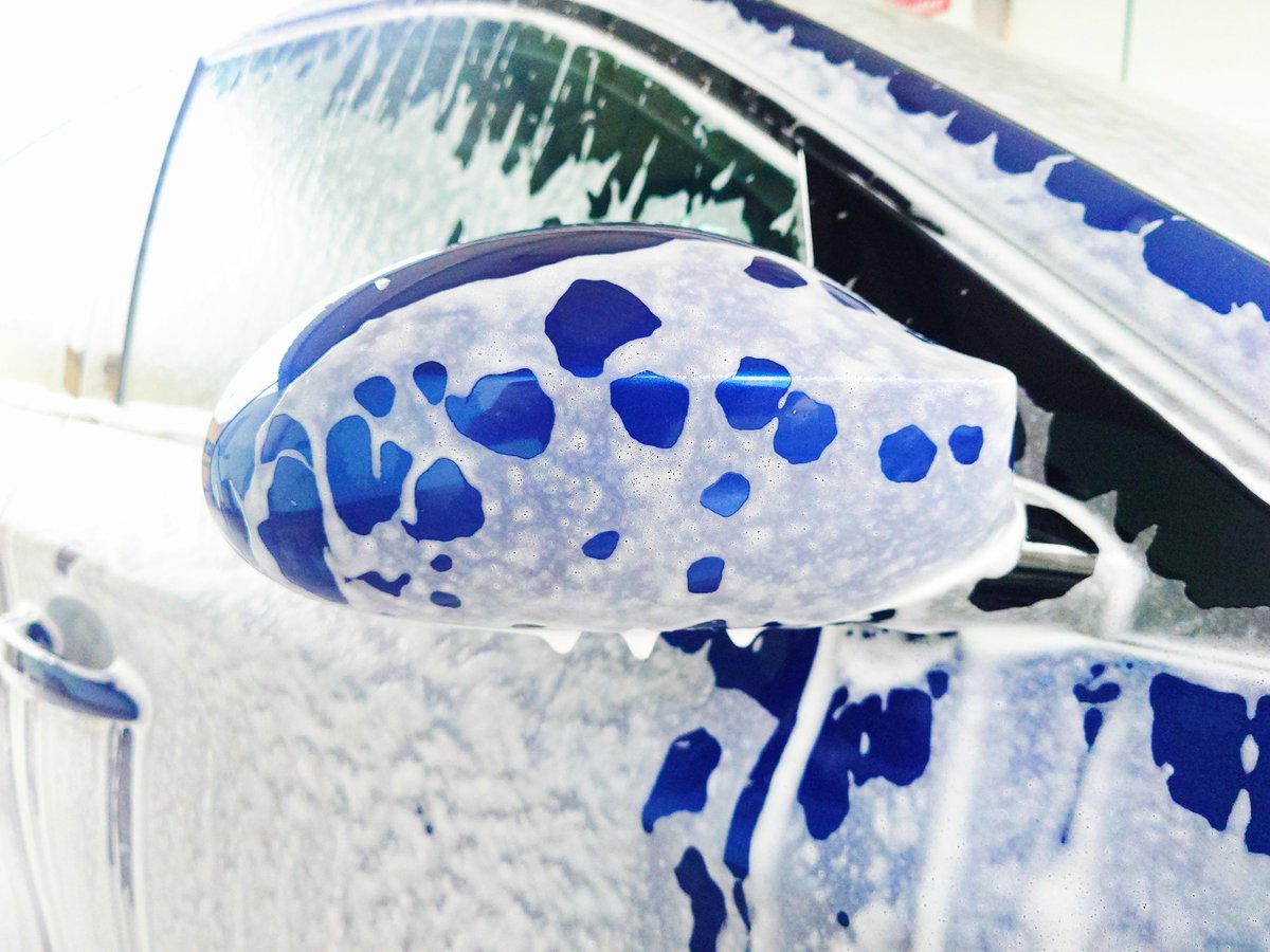 Auto blu coperta di schiuma al self service